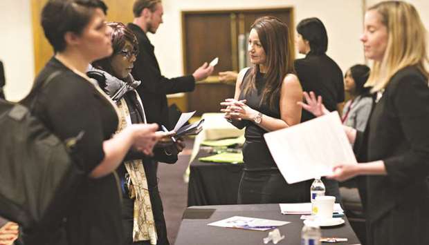 Company representatives talk with job seekers during a job fair in Chicago, Illinois (file). The US economy created the fewest jobs in six months in March as the boost from mild temperatures faded, but a pickup in wage gains pointed to a tightening labour  market, which should allow the Federal Reserve to raise interest rates further this year.