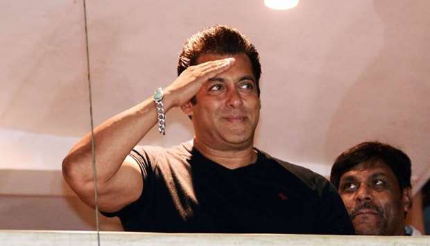 Indian Bollywood actor Salman Khan waves to fans after reaching home at Bandra in Mumbai