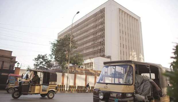 Auto rickshaws travel past the State Bank of Pakistan building in Karachi. Pakistanu2019s real GDP growth is expected to surpass last yearu2019s decade-high growth rate of 5.3% but will remain below the target of 6% with four-year high large-scale manufacturing growth and low inflation, the SBP said yesterday.