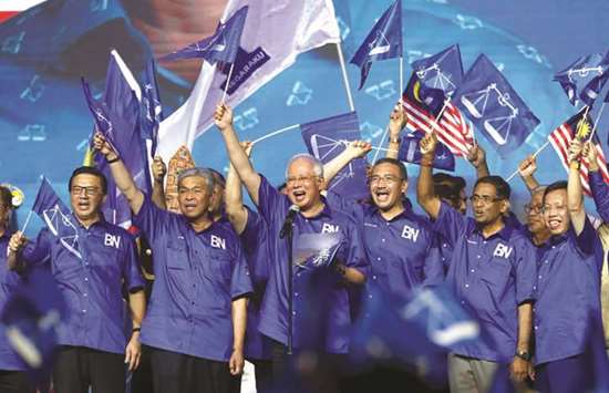 Malaysiau2019s Prime Minister and president of ruling party National Front, Najib Razak and other party leaders wave the party flags during the launch of its manifesto for the upcoming general elections in Kuala Lumpur, yesterday.