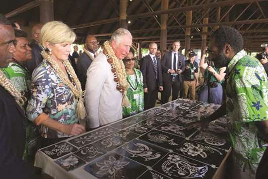 Britainu2019s Prince Charles speaks to a local artist as he and Australiau2019s Foreign Minister Julie Bishop visit a market house in Port Vila, Vanuatu, yesterday.