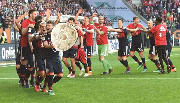 Bayern Munich players celebrate their Bundesliga title win with a replica of the trophy after the match against Augsburg yesterday. (AFP)