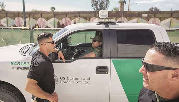 Border Patrol agents gather along the border fence on April 6, 2018 in Calexico, California.