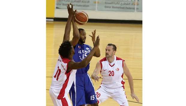 Al Shamalu2019s Mathew Bryan-Amaning (left) vying for the ball with Al Khoru2019s Dominique Montes Lacy as Hrvoje Puljko looks on during their Emir Cup basketball tournament match yesterday.