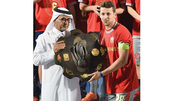 Al Duhail captain Youssef Msakni receives the QNB Stars League winning shield from Qatar Football Association vice-president Saoud al-Mohannadi on Saturday. The Tunisian will miss the 2018 World Cup after suffering a cruciate ligament injury.