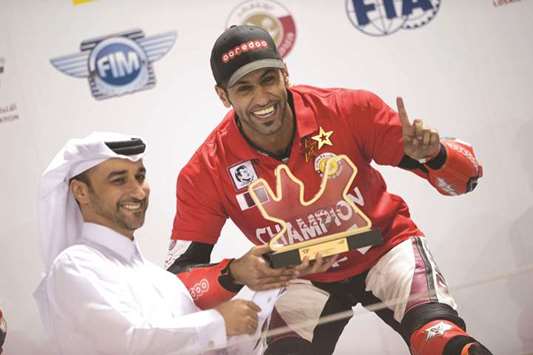 QMMF general secretary Abdulrazak al-Kuwari (left) presents the winneru2019s trophy to Qatar Superstock 600 champion Saeed al-Sulaiti at the Losail International Circuit on Saturday.