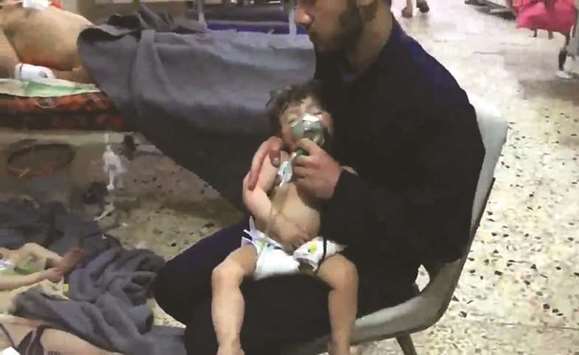 An image grab taken from a video released by the Syrian civil defence in Douma shows an unidentified volunteer holding an oxygen mask over a childu2019s face at a hospital  following a reported chemical attack on the rebel-held town, yesterday. Right: A picture taken yesterday, shows Syrian Army soldiers gathering in an area on the eastern  outskirts of Douma, as they continue their fierce offensive to retake the last opposition holdout in Eastern Ghouta.