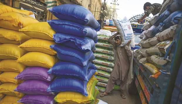 Workers unload rice sacks at a wholesale market in Karachi. Pakistan governmentu2019s battle against bloated trade deficit is finally bearing fruit as it shrank by 14% to $23.45bn in the first nine months of the current fiscal year from $27.29bn in the corresponding period last year.