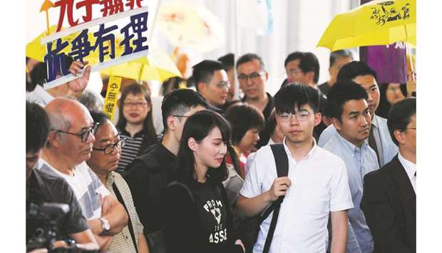 Former student leader Joshua Wong and activist Agnes Chow arrive at the court to support leaders of Occupy Central activists, in Hong Kong, China.