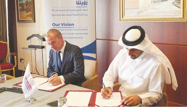 Khalifa bin Jassim al-Kuwari and Khalid Koser sign the agreement.