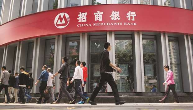 Pedestrians walk past a China Merchants Bank Co branch in Guangzhou, China. The Shenzhen-based lender focuses on retail banking in China, a business thatu2019s more profitable and less capital-intensive than lending to corporates.