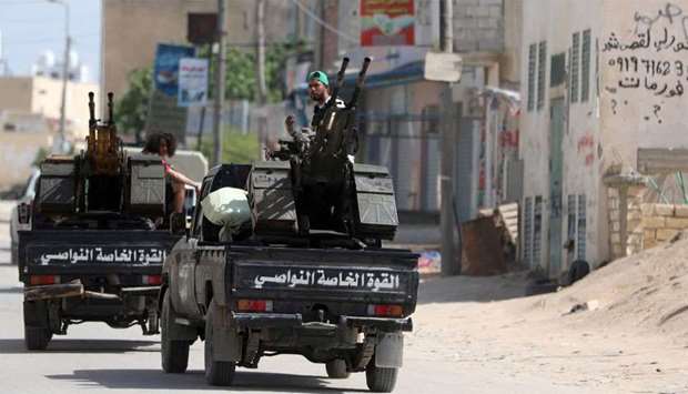 Members of Libyan internationally recognised pro-government forces ride in military vehicles on the outskirts of Tripoli