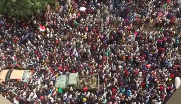 People are seen in the streets after televised statement by Defence Minister Awad Mohamed Ahmed Ibn Auf in Khartoum