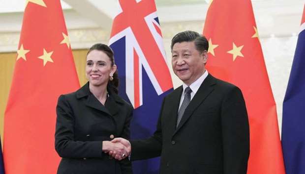 China's President Xi Jinping (R) shakes hands with New Zealand's Prime Minister Jacinda Ardern