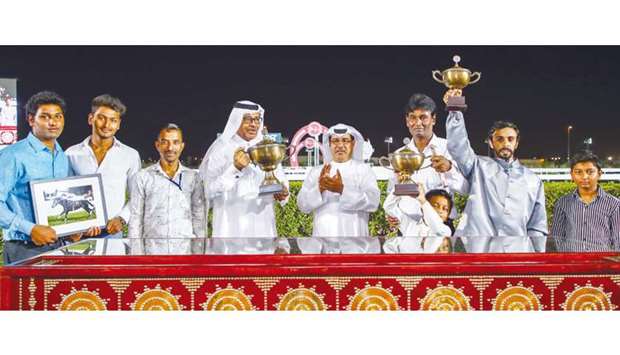 Qatar Racing and Equestrian Club Racing manager Abdulla Rashid al-Kubaisi with the winners of the Al Mamoura Cup after Darkanna won the seven furlong feature at Al Rayyan Park yesterday. PICTURES: Juhaim