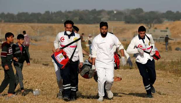 Palestinian paramedics carry an injured protester during a demonstration near the border between Israel and Khan Yunis in the southern Gaza Strip