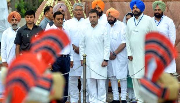 Indian National Congress party president Rahul Gandhi (C), Punjab Chief Minister Amarinder Singh (3R), Punjab cabinet minister Navjot Singh Sidhu (2R), Punjab Congress president Sunil Jakhar (5L in white) look at the guards of honour's performance to pay tribute on the 100th anniversary of the Jallianwala Bagh massacre at the Jallianwala Bagh martyrs memorial in Amritsar