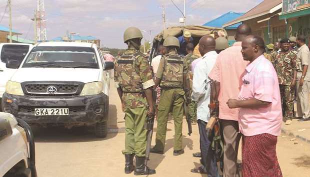 Security officers and civilians stand next to the car where gunmen abducted two Cuban doctors as they were going to work, in Mandera county, Kenya, yesterday.