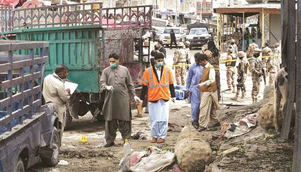 Security officers inspect the site of a bomb blast at the fruit market in Quetta.
