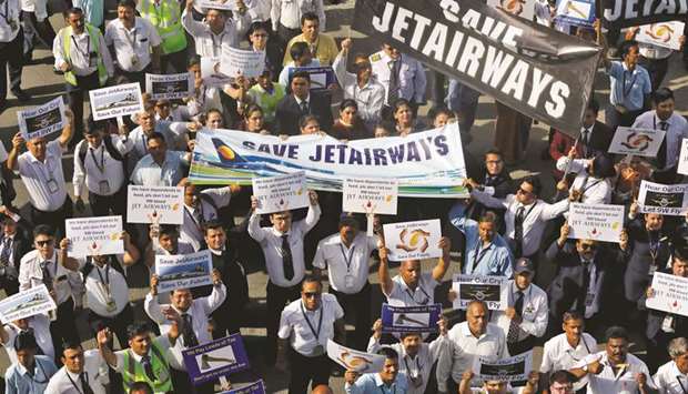 Jet Airways employees hold placards and banners during a protest at the Indira Gandhi International Airport in New Delhi yesterday.