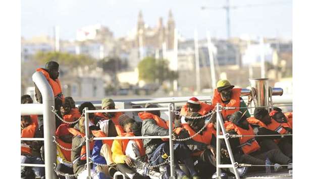 Migrants who were stuck on a ship since their rescue in the Mediterranean 10 days ago, arrive to disembark in Valletta.