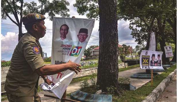 A member of Indonesiau2019s Public Order Service (Satpol PP) takes down election campaign banners in Pekanbaru yesterday following the end of the campaigning period ahead of the April 17 polls.