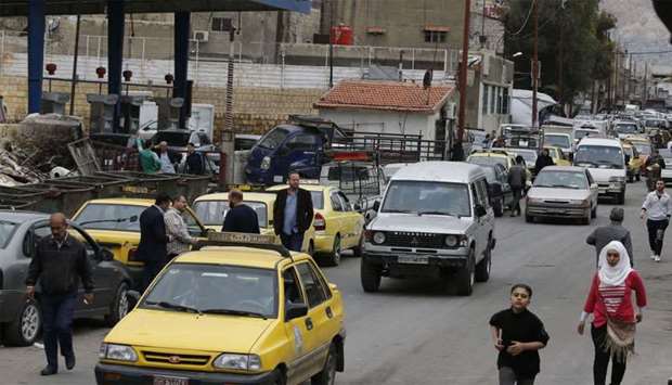 Drivers queue for gasoline in front of a petrol station in the Syrian capital Damascus