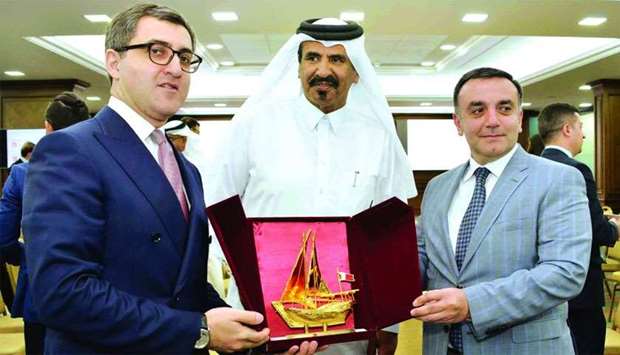 Al-Kuwari hands over a token of recognition to Oglu in the presence of Ismayilov.rnrn
