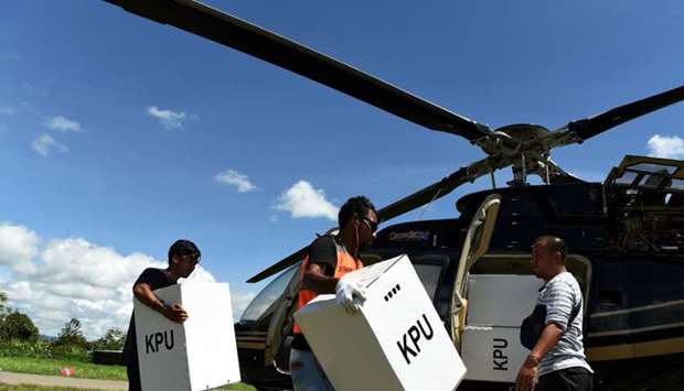 Officials carry election materials to be distributed by helicopter at Wamena airport in Jayawijaya, Papua, Indonesia on April 13. Antara Foto/Yusran Uccang/ via REUTERS