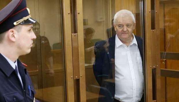 Frode Berg stands inside a defendants' cage as he waits to hear his verdict in Moscow.
