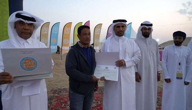 WINNER: From left, Salman al-Malik, Director of the Center for Visual Arts; Michael Conjusta, first place winner of the sand art competition, and Hamad al-Zekaiba, Director of the Culture and Arts Department of the Ministry of Culture and Sports, with organisers during the award ceremony.            Photo supplied