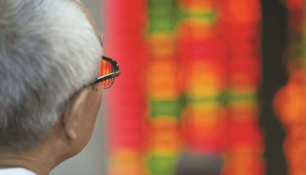 An investor watches his stocks at a securities exchange in Shanghai (file). In China specifically, the first in Asia to enter a bull market this year, the Shanghai Composite Index posted its worst week this year.