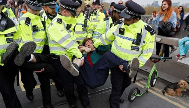 Police officers detain a climate change activist at Waterloo Bridge during the Extinction Rebellion protest in London, Britain
