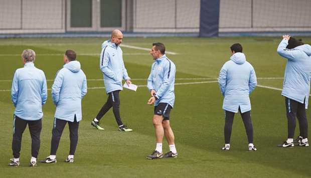 Manchester City manager Pep Guardiola with his team during a training in Manchester, yesterday. (Reuters)