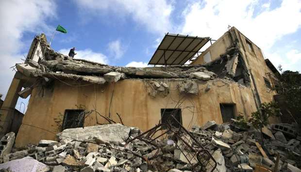 A Hamas flag stands on the roof of the house of Palestinian Salah Barghouti after it was partially demolished by Israeli forces in the village of Kobar near Ramallah, in the Israeli-occupied West Bank