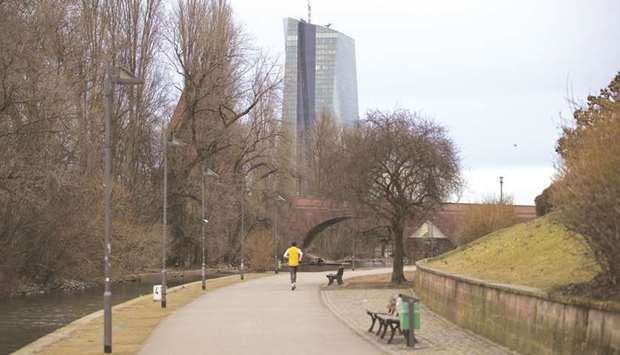 A jogger runs along the bank of the River Main towards the European Central Banku2019s skyscraper headquarters in Frankfurt. The ECB has been looking for ways to combat an economic slowdown that threatens to frustrate its attempts to deliver sustainable inflation for the euro region. In March, it downgraded its growth outlook and unveiled a new bank-lending programme just three months after halting asset purchases.
