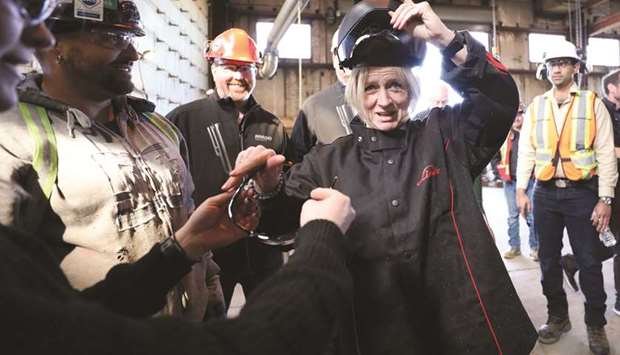 Alberta New Democratic Party leader and Premier Rachel Notley puts on welding equipment during a campaign event at Nardei Fabricators in Calgary on Monday.