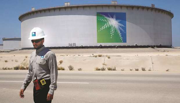 An Aramco employee walks near an oil tank at the Ras Tanura oil refinery and oil terminal in Saudi Arabia (file). Aramco bonds have been slumping since an unprecedented debt sale earlier this month.