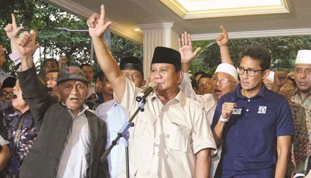 Indonesian presidential candidate Prabowo Subianto (centre) and vice presidential candidate Sandiaga Uno (right) gesture as they declare victory in the countryu2019s election, during a press conference in Jakarta.