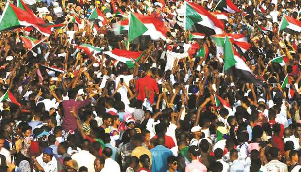 Sudanese demonstrators wave their national flags during a protest outside Defence Ministry in Khartoum.