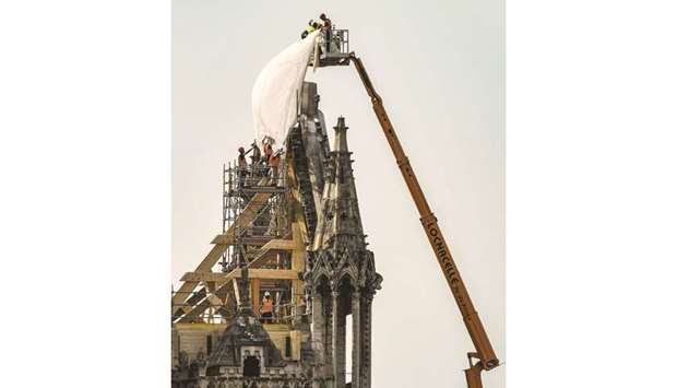 Workers are seen at the Notre-Dame Cathedral in Paris, three days after a fire devastated the building.