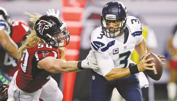 In this January 14, 2017, picture, Atlanta Falconsu2019 Brooks Reed (left) tries to tackle Russell Wilson of the Seattle Seahawks at the Georgia Dome in Atlanta, Georgia. (AFP)
