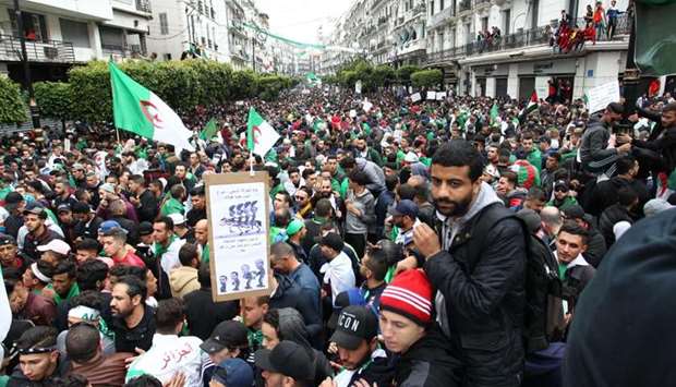 Algerians, waving national flags, march during an anti government demonstration in the capital Algiers