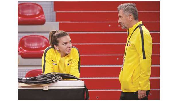 Romania captain Florin Segarceanu with Simona Halep during a training session in Rouen, France, yesterday. (Reuters)