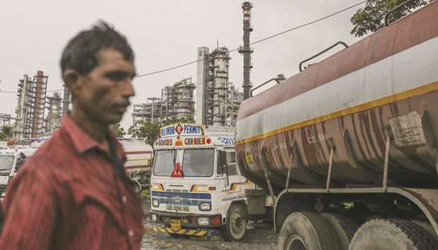 A pedestrian walks past trucks parked in front of the Bharat Petroleum Corp refinery in the Mahul area of Mumbai (file). All four Indian state-owned refiners that buy Iranian oil are confident of securing additional barrels from other producers, officials from the companies told Reuters.
