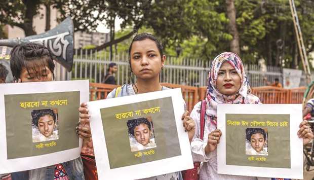 Women hold placards and photographs of schoolgirl Nusrat Jahan Rafi at a protest rally in Dhaka, following her murder by being set on fire after she had reported a sexual assault.