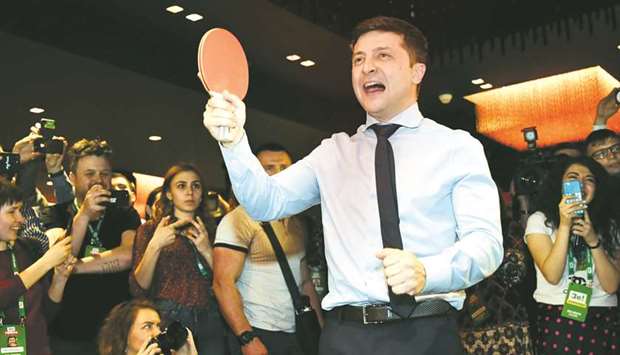 Zelenskiy plays table tennis with a journalist ahead of the provisional results at his campaign headquarters in Kyiv.