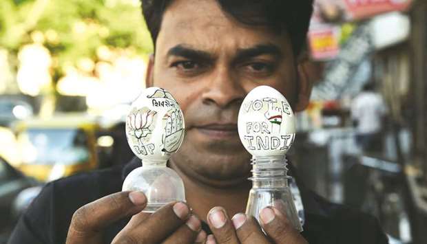 Artist Salimbhai Shaikh holds eggs shells displaying carvings depicting the Bharatiya Janata Party and the Congress and the message of u201cVote For Indiau201d in Ahmedabad yesterday.