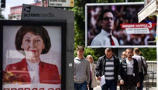 People walk past electoral posters of presidential candidates Stevo Pendarovski (R) from the ruling SDSM party and Gordana Siljanovska from the Vmro Domn opposition party (L) in Skopje