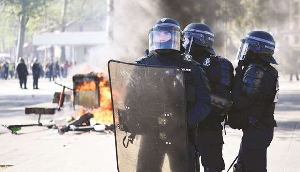 Anti-riot police personnel hold a position during clashes in Paris, as thousands of u2018yellow vestu2019 (Gilets Jaunes) protesters took to the streets a 23rd week of anti-government marches.